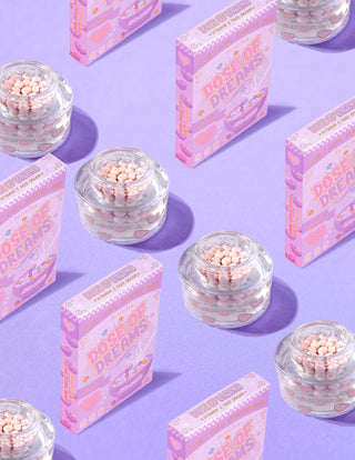 Clear containers of P.Louise DOse of Dreams Viatmin C Capsule Face Cream with pink capsule in them surrounded by pink cereal boxes on a purple background