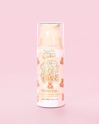 Bottle of P.Louise Just A Foamy Phase gentle foaming face wash in a coconut cake scent against a pink background