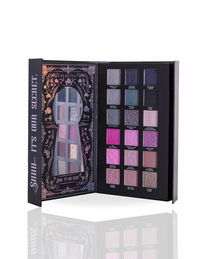 Page 2 of a halloween eyeshadow palette by P.Louise showing 16 shades, displayed open to show both the decorated black outer cover with a mirror and the inner palette containing various shades of purple, pink, blue, and gray.