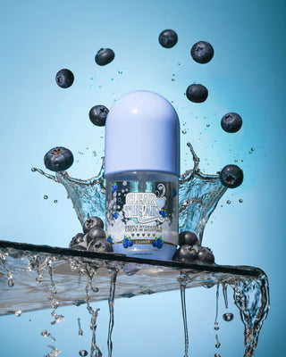 Bottle of P. Louise Clear The Air Blueberry Gel Cleanserl surrounded by blueberries and water splashes on a blue background