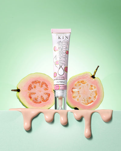 Tube of P.Louise Dose Of Dreams Vitamin C Brightening Eye Cream surround by guava fruit on a green background