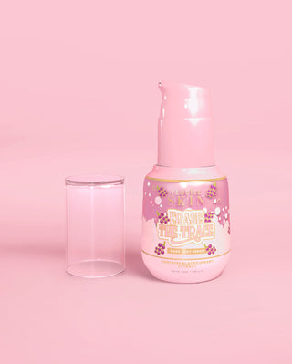 Pink bottle of P. Louise Erase The Trace Dark Spot Correcting Serum with the lid off on a pink background