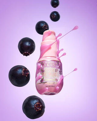 Pink bottle of P. Louise Erase The Trace Dark Spot Correcting Serum with liquid coming off the bottle surrounded by blackcurrants on a purple background
